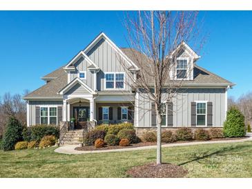 Charming two-story home with gray siding, stone accents, shutters, and a meticulously landscaped front yard at 190 Hidden Meadows Dr, Mooresville, NC 28117