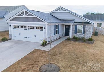 Charming single-story home with stone accents, a two-car garage, and a well-manicured lawn at 239 Damask Dr, Lancaster, SC 29720
