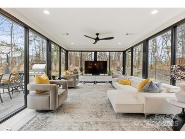 Bright living room features floor-to-ceiling windows, contemporary furnishings, and views of a wooded backyard at 341 Beckwick Ln, Concord, NC 28025