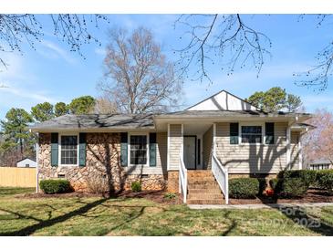 Inviting home exterior featuring stone accents, manicured lawn, and charming front porch at 345 Briar Creek Rd, Gastonia, NC 28056