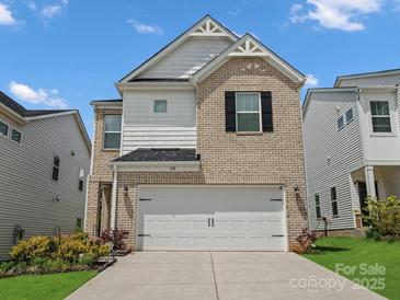 Charming two-story home featuring a brick and siding facade, two-car garage and manicured lawn at 518 Palmarosa St, Fort Mill, SC 29715