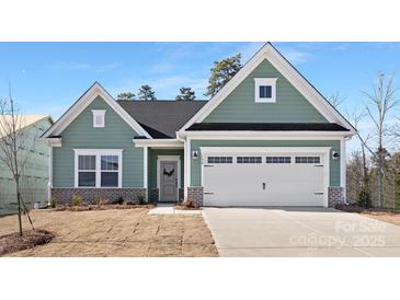 Inviting one-story home boasts a two-car garage, manicured lawn, and charming architectural details at 134 Montgomery Pl # 708, Mount Gilead, NC 27306