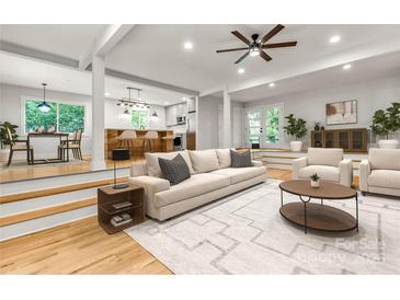 Bright living room with hardwood floors, neutral decor, open to kitchen and dining areas at 16137 Tana Tea Cir, Tega Cay, SC 29708