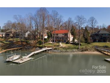 Waterfront home featuring a private dock, lush landscaping, and multi-level deck perfect for lakeside living and entertaining at 170 W Maranta Rd, Mooresville, NC 28117