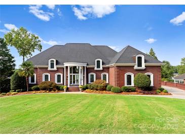 Stunning brick home featuring a manicured lawn, arched windows, and a grand entrance portico at 249 Blue Heron Dr, Rock Hill, SC 29732