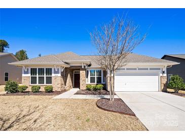 Inviting single-story brick home featuring a well-manicured lawn, two-car garage and covered entryway at 2914 Hiddenbrook Way, Indian Land, SC 29707