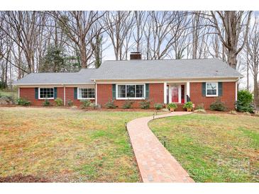 Charming single-story brick home featuring a walkway, manicured lawn, and mature trees at 329 N Oakwood Dr, Statesville, NC 28677