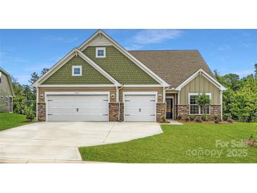Charming home featuring a three-car garage, stone accents, and a well-manicured lawn at 4134 Camden Glen Rd, Lancaster, SC 29720