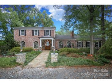 Charming brick home with a manicured lawn, stone walkway, and a covered front entrance at 419 Park Ridge Rd, Albemarle, NC 28001