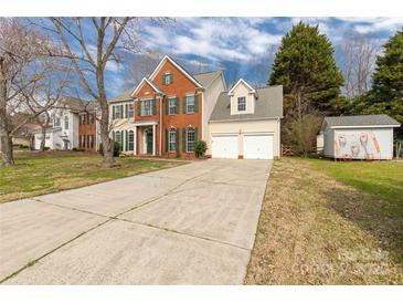Traditional two-story home with attached two-car garage and long driveway offering ample parking space at 9138 Babbitt Way, Charlotte, NC 28216