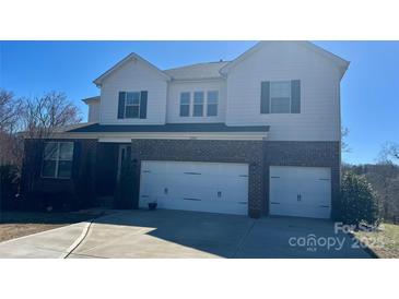 Charming two-story home with a brick and white facade, complemented by a two-car garage and well-maintained landscaping at 11296 Serenity Farm Dr, Midland, NC 28107