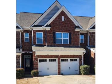 Charming brick townhome with a two-car garage and well-maintained front landscaping at 113 Burlingame Ct # D, Mooresville, NC 28117