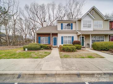 Charming townhome featuring blue shutters, a well-manicured lawn, and a welcoming entrance at 12601 Tucker Crossing Ln, Charlotte, NC 28273