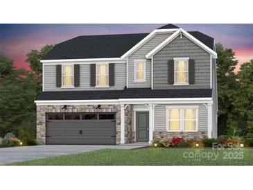 Charming two-story home featuring a stone-accented garage, gray siding, and classic black shutters at 3850 Pee Dee St # 44, Monroe, NC 28110