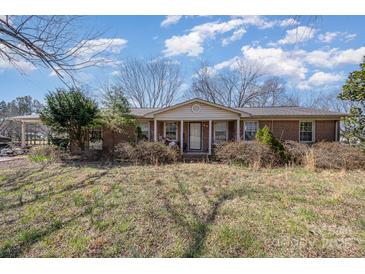 Charming single-story brick home with a covered front porch, mature landscaping, and a well-maintained lawn at 607 Dick St, Albemarle, NC 28001