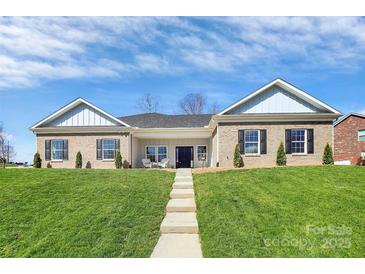 Charming brick home featuring black shutters, well-manicured lawn, and inviting front porch seating at 609 Rosemore Pl, Rock Hill, SC 29732