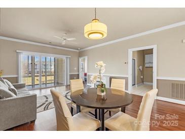 Inviting living room featuring a dining area, hardwood floors, and abundant natural light at 8923 Meadow Vista Rd, Charlotte, NC 28213