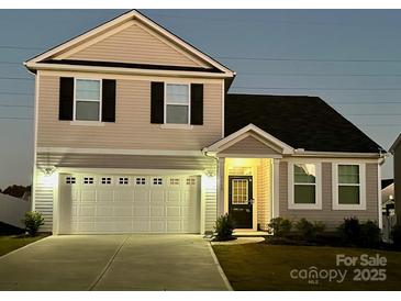 Charming two-story home features a two-car garage, a well-maintained lawn and classic architectural details at 1008 Hills Oak Ln, Charlotte, NC 28269