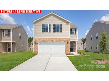 New two-story home with a two-car garage, brick accents, and a well-manicured lawn at 11217 Cardinal Creek Ave, Charlotte, NC 28215
