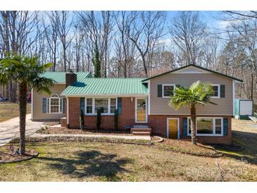 Charming home with a well-maintained lawn and a striking green roof at 121 Alexis Forest Dr, Stanley, NC 28164