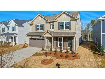 Charming two-story home showcasing neutral siding, a two-car garage, and manicured landscaping at 13729 Roderick Dr # 188, Huntersville, NC 28078