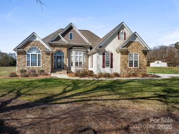 Charming single-Gathering home featuring a stone facade, gabled roof, and a well-manicured lawn at 16160 Hopewell Church Rd, Midland, NC 28107