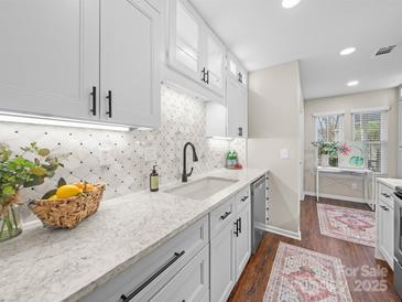 Bright kitchen features shaker cabinets, speckled quartz counters, and a stylish mosaic backsplash at 2727 Tiergarten Ln, Charlotte, NC 28210