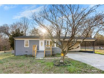 Cozy single-story home with gray brick, mature landscaping, and attached carport at 2729 Springbrook Cir, Gastonia, NC 28052