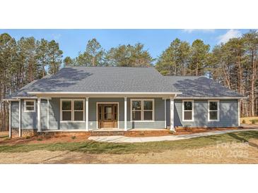 Charming single-story home featuring a welcoming front porch and professionally landscaped yard at 326 Lewis Ferry Rd, Statesville, NC 28677