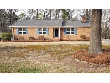 Charming brick ranch home with blue shutters and well-maintained landscaping at 501 Catawba N Cir, Matthews, NC 28104