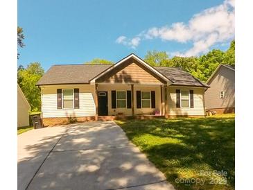Charming single-story home featuring a concrete driveway, well-manicured lawn, and inviting curb appeal at 648 E Ketchie St, China Grove, NC 28023