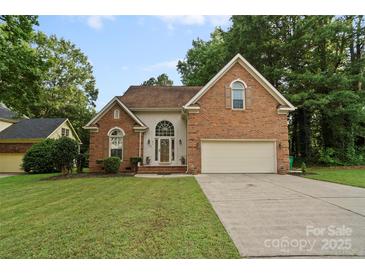 Charming brick home featuring an attached two-car garage and well-manicured lawn at 8731 Sheltonham Way, Charlotte, NC 28216