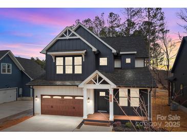 Beautiful exterior elevation with dark siding, wood garage door, and tasteful architectural details at 119 Mills Garden Rd, Statesville, NC 28625