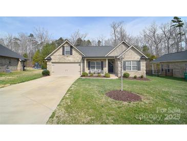 Charming brick home featuring an attached two-car garage and well-maintained lawn at 12889 Hill Pine Rd, Midland, NC 28107