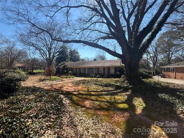 Charming single-story home with mature trees and a lush front yard at 201 Wingrave Dr, Charlotte, NC 28270