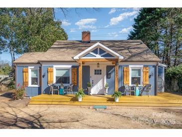 Charming blue house with a covered porch and light wood shutters creates an inviting curb appeal at 2137 Highland St, Charlotte, NC 28208