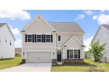 Charming two-story home featuring neutral siding, black shutters, and well-maintained landscaping at 122 Asmodean Ln, Troutman, NC 28166