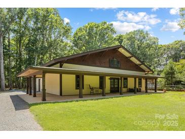 Inviting craftsman-style home with a sprawling covered porch and lush green lawn at 13124 Lemmond Dr, Matthews, NC 28105