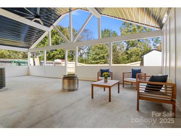 Covered patio featuring an outdoor seating area with modern furniture, a fire pit, and a spacious seating area at 3009 Rockingham Sw Ct, Concord, NC 28025