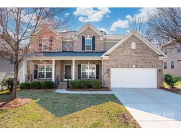 Charming brick home featuring a well-manicured front lawn and attached two-car garage, enhancing its curb appeal at 8025 Penman Springs Dr, Waxhaw, NC 28173