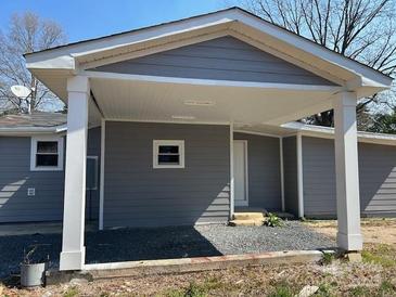 Charming gray house with a covered carport, small windows, and gray stone landscaping at 811 Sanford St, Marshville, NC 28103