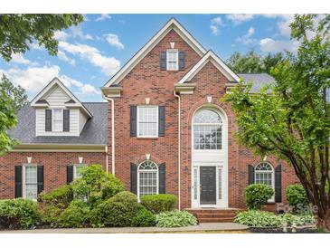 Charming brick two-story home featuring black shutters and a lush, landscaped front yard at 9423 Belmont Ln, Marvin, NC 28173
