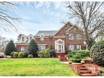 Elegant two-story brick home with manicured lawn and charming architectural details at 9800 Deer Brook Ln, Charlotte, NC 28210