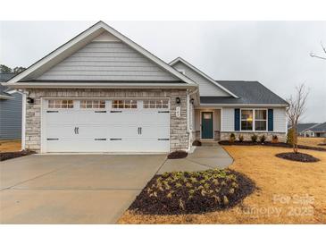 Charming single Gathering home with stone accents, two-car garage, and nicely landscaped yard at 143 Commerce Blvd, Lancaster, SC 29720