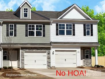 Charming two-story townhome featuring a garage and a beautifully designed exterior with stone accents and black shutters at 2021 Mcdonald Dr, Charlotte, NC 28216