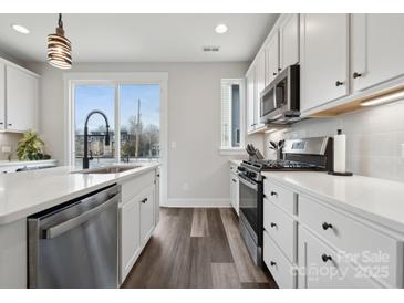Bright kitchen featuring stainless steel appliances, white cabinets, and hardwood floors at 2132 Electric Ln, Charlotte, NC 28205