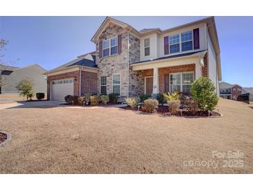 Charming two-story home with stone and brick exterior, landscaped yard, and attached two-car garage at 2598 Bryant Dr, Fort Mill, SC 29707