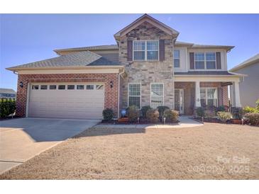 Beautiful two-story home with brick and stone exterior, two car garage, and well-manicured front lawn at 2598 Bryant Dr, Fort Mill, SC 29707
