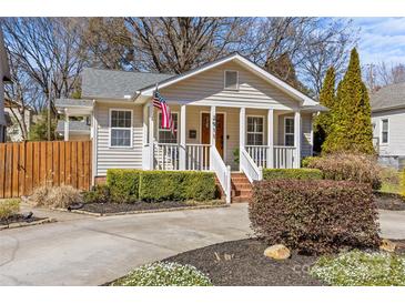Charming home featuring a welcoming front porch, mature landscaping, and a well-manicured lawn at 2911 N Myers St, Charlotte, NC 28205