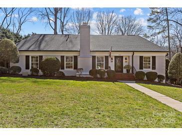 Charming single story home featuring a brick facade, manicured lawn, and beautiful landscaping at 4300 Denbigh Dr, Charlotte, NC 28226